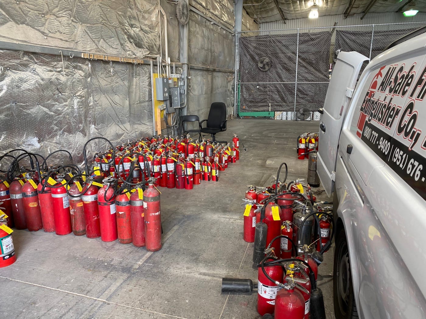 All-Safe’s service van beside rows of portable extinguishers in the shop